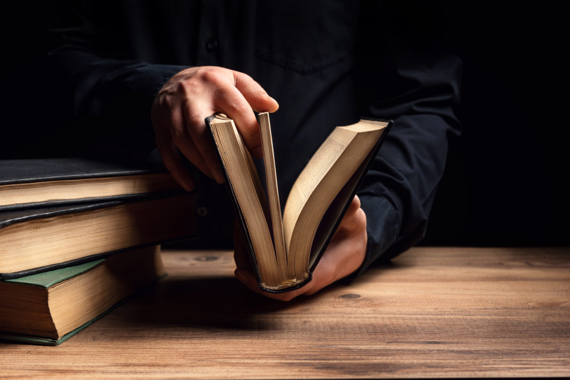 Man illuminates the darkness by reading a book