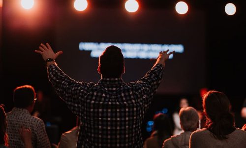 man-standing-infront-of-stage-lifting-hands
